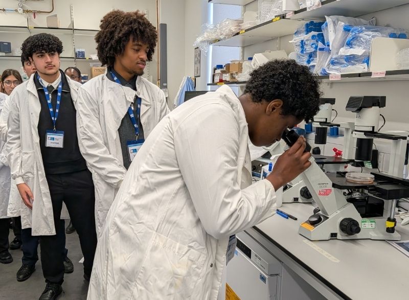 YCC Students in the lab A group of students around a microscope
