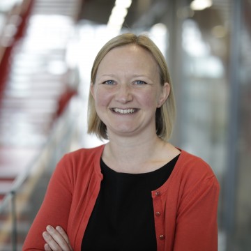 White woman scientist Dr Alexis Barr standing inside research institute