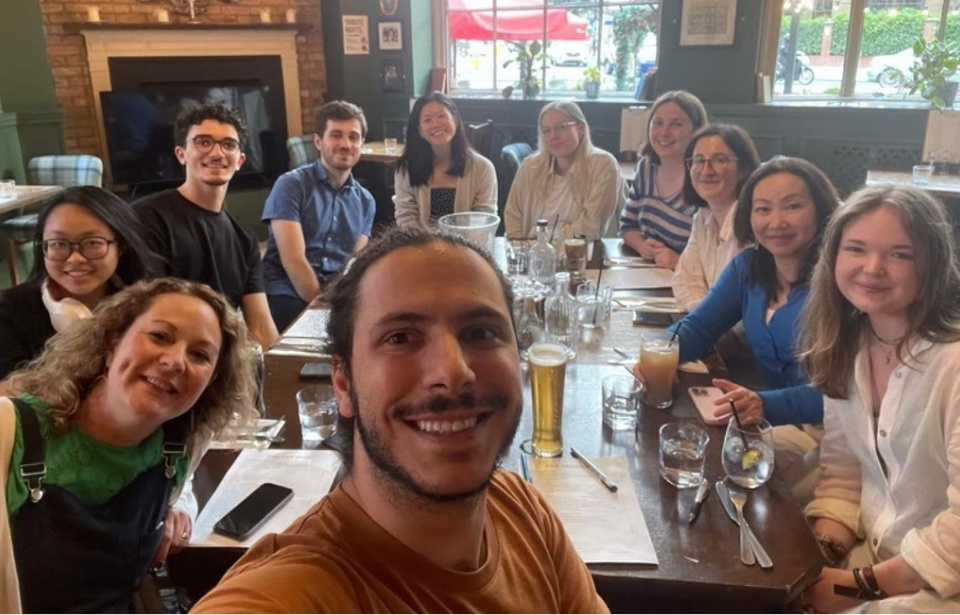 A photo of the smiling lab group members in the pub