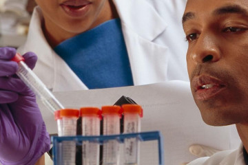 man looking at test tube in a lab
